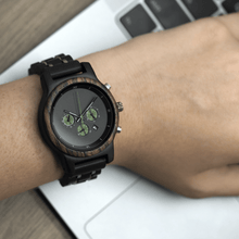 Load image into Gallery viewer, person wearing ebony wooden watch while working on a computer
