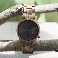 Load image into Gallery viewer, Zebrawood wooden watch hanging off of a tree branch
