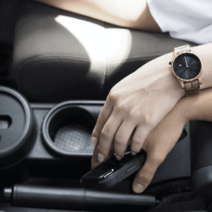 Woman wearing wooden watch in car and holding someone's hand