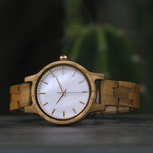 Load image into Gallery viewer, Olive wood watch with pearlized face laying on its side
